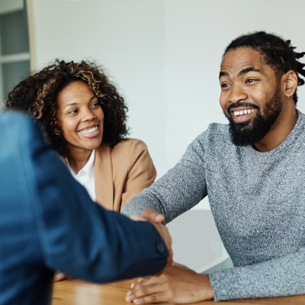 Couple meeting with a property professional to discuss selling their home